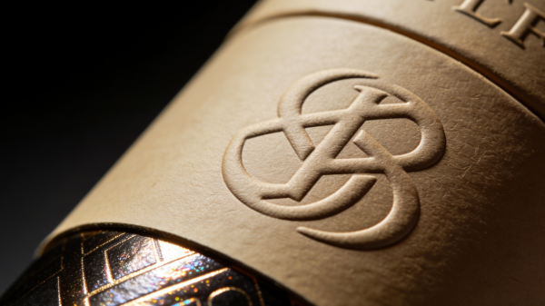 Close-up of custom rigid box with gold foil stamping, embossing, textured paper, and spot UV finish