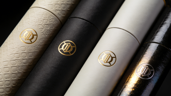 Close-up comparison of paper tube packaging finishes including embossing, foil stamping, matte lamination, and spot UV coating