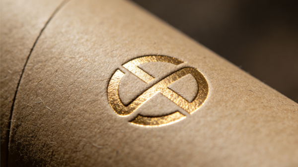 Close-up of paper tube packaging with foil stamping and embossing logo